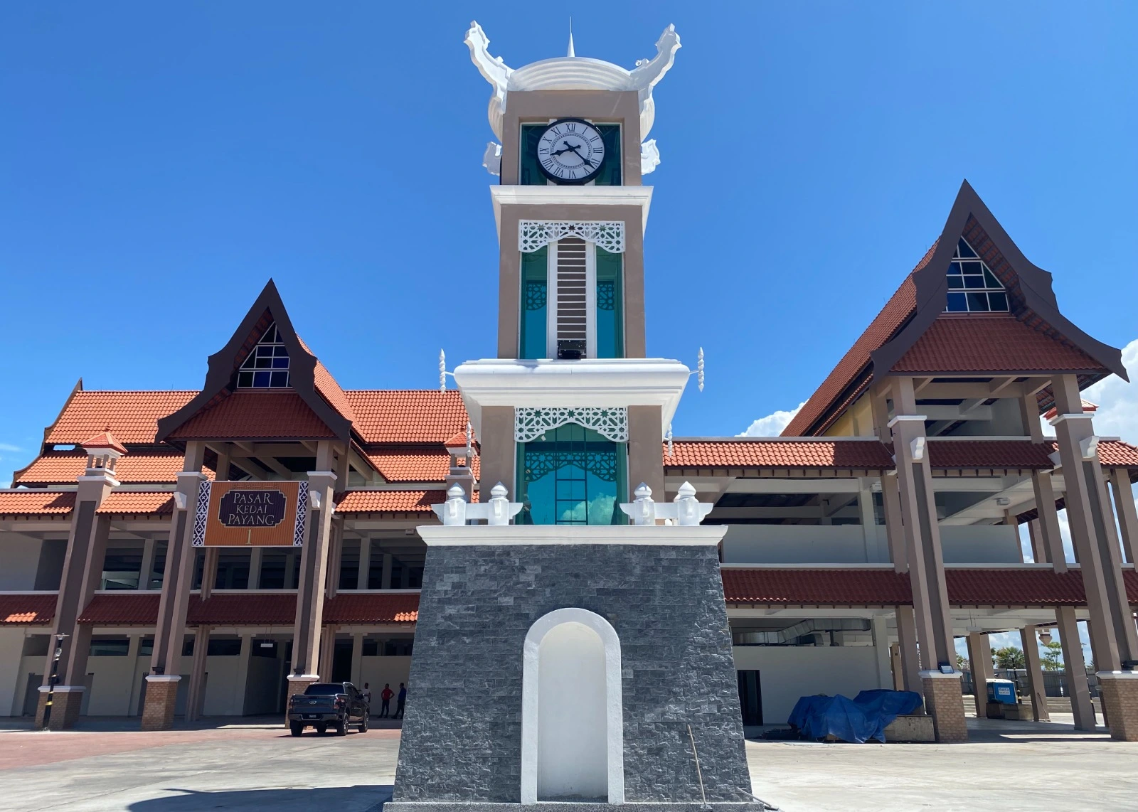 Menara jam di hadapan Payang Baru Terengganu dengan reka bentuk moden dan bangunan Pasar Kedai Payang di Kuala Terengganu.