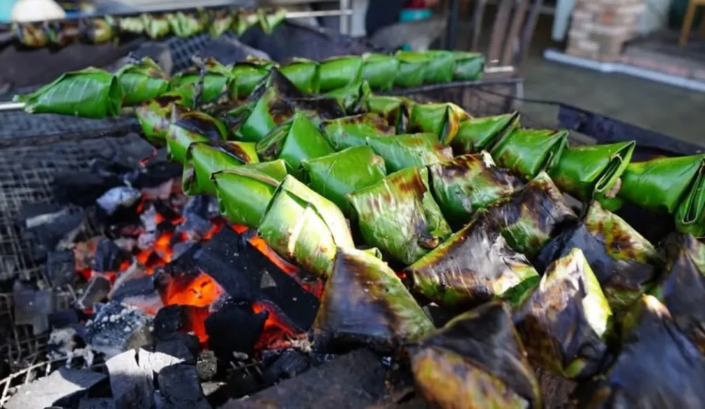 gambar menunjukkan sebuah makanan yang ada daun pisang atau daun yang berwarna hijau