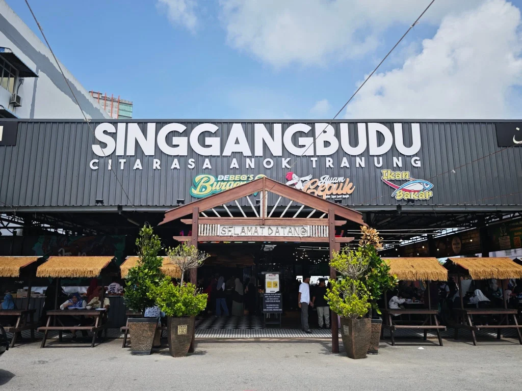 ada signboard hitam besar,langit biru dan awangan serta tempat makan